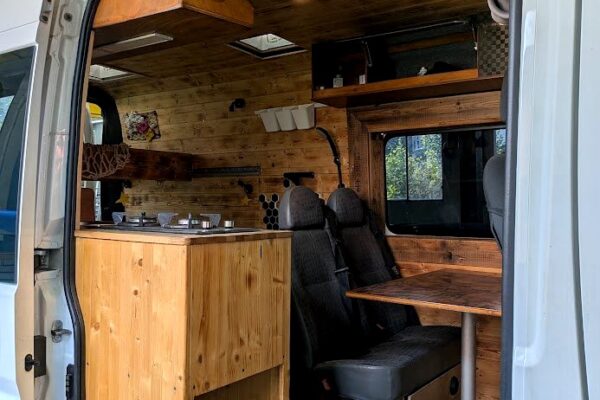 Intérieur de van aménagé en bois avec kitchenette
