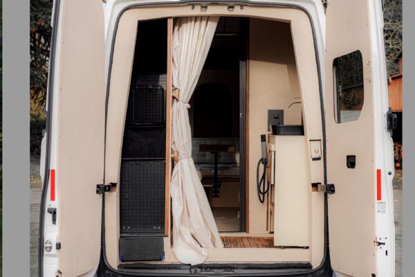 Arrière d’un van aménagé aux portes ouvertes