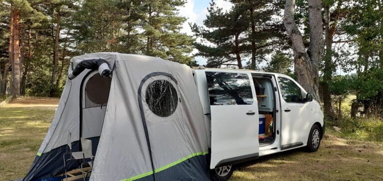 Van aménagé avec tente annexe en forêt
