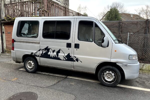Fourgon blanc avec motif montagne garé en rue