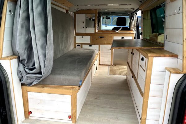 Intérieur aménagé d'un van avec lit et rangements