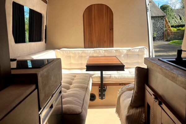 Intérieur aménagé d’un van avec coin repas lumineux