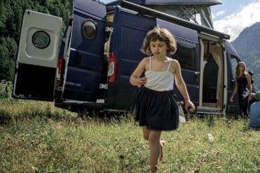 Fillette marchant près d’un van aménagé en montagne