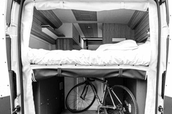 Innenausstattung van aménagé mit Hochbett und Fahrrad