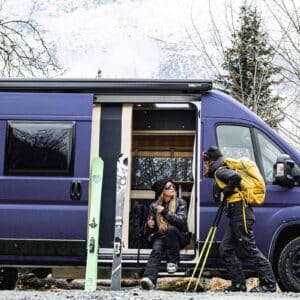 Deux skieurs devant van aménagé en forêt