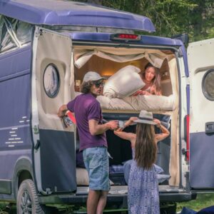 Amis préparant un van aménagé en pleine nature