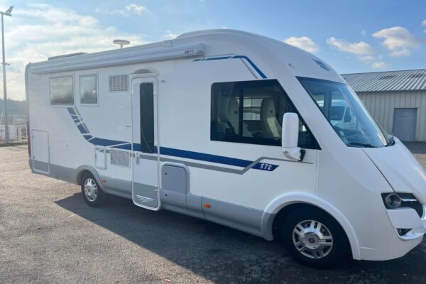 Camping-car blanc stationné sur un parking extérieur