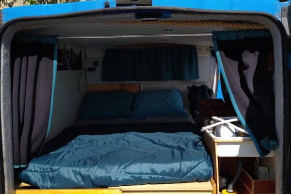 Intérieur aménagé d’un van avec lit et rangements
