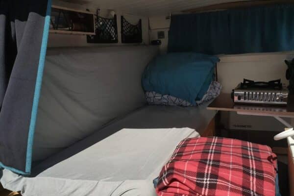 Intérieur aménagé de van avec lit et kitchenette