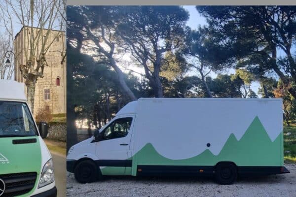 Camion aménagé vert et blanc en forêt