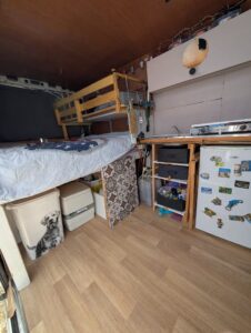 Intérieur aménagé d’un van avec lit et kitchenette
