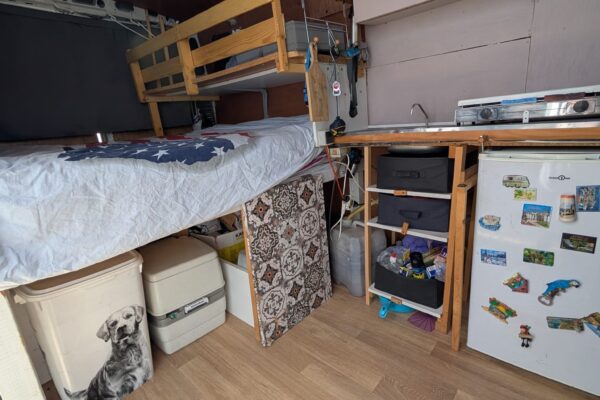 Intérieur aménagé d’un van avec lit et kitchenette