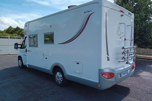 Camping-car blanc stationné sur un parking extérieur