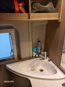Petit lavabo avec robinet et étagères en bois