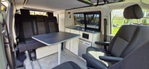 Intérieur de van aménagé avec table et kitchenette