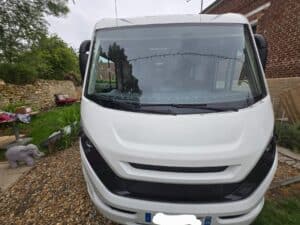 Camping-car blanc stationné dans une cour