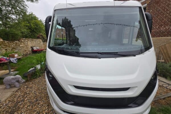Camping-car blanc stationné dans une cour
