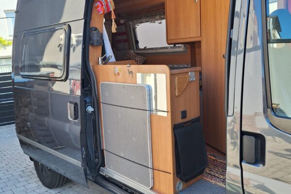 Intérieur aménagé d’un van avec kitchenette en bois