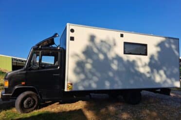Camion convertito bianco e nero sotto un cielo blu