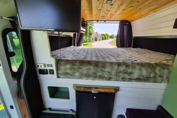 Interno dell'Van camperizzato con letto e vista esterna