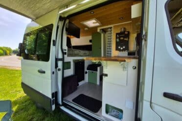 Intérieur aménagé d’un van avec cuisine et lit