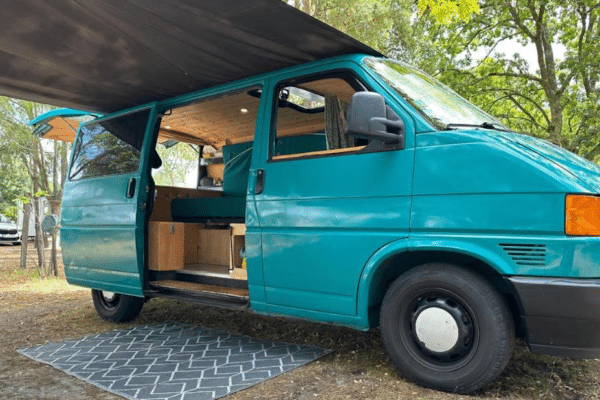 Van aménagé vert avec auvent ouvert