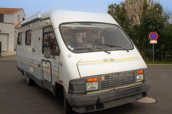 Camping-car blanc stationné dans une rue résidentielle