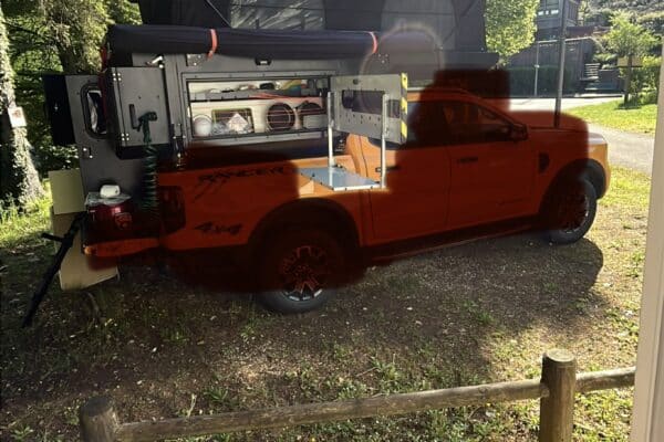 Pick-up aménagé avec tente de toit en forêt