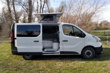Fourgon aménagé blanc avec toit relevable ouvert