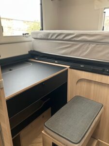 Intérieur de van aménagé avec bureau et lit