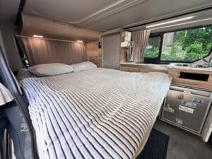 Intérieur de van aménagé avec lit et kitchenette