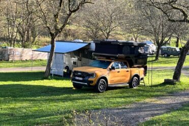 Pick-up giallo con tente de toit al campeggio