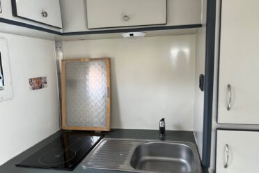 Petit coin cuisine avec évier et plaque
