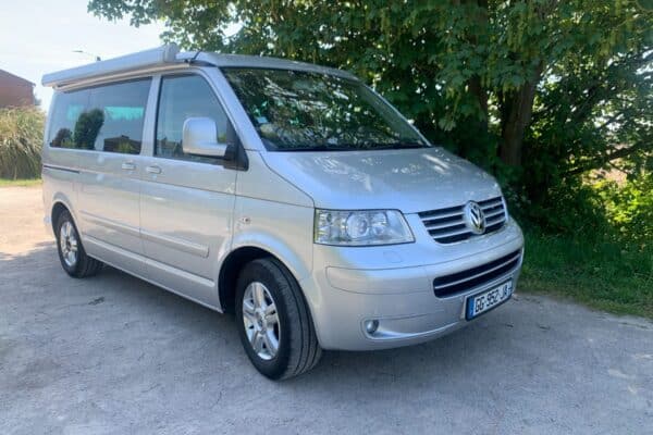 Van Volkswagen argenté garé près d’arbres
