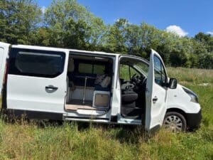 Van aménagé blanc dans un champ ensoleillé