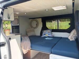 Intérieur aménagé d’un van avec lit et fenêtre