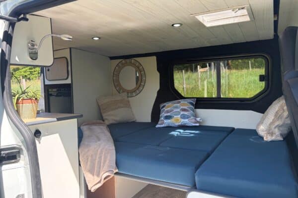 Intérieur aménagé d’un van avec lit et fenêtre