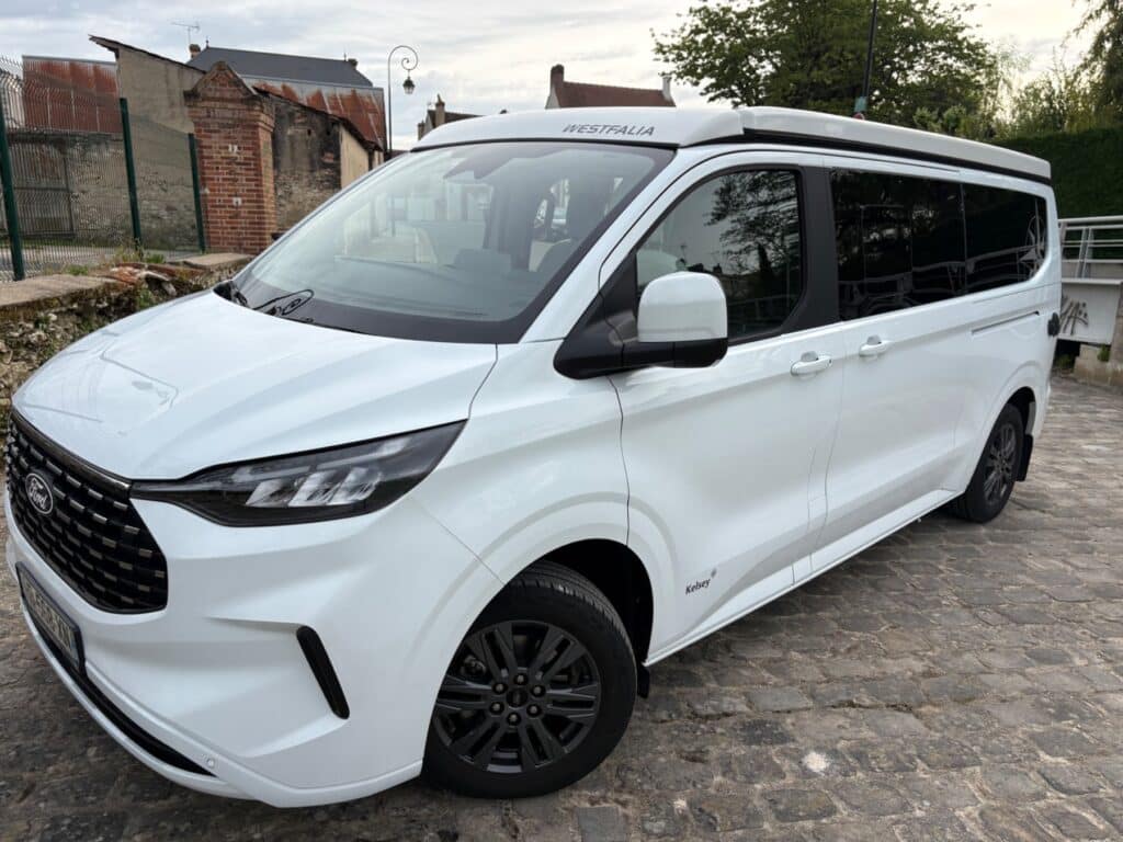 Van aménagé blanc Westfalia garé en ville