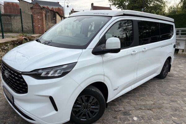 Van aménagé blanc Westfalia garé en ville