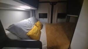 Chambre compacte avec lit et coussins jaunes