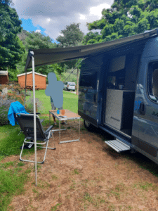 Van aménagé avec auvent dans un camping