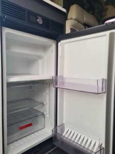 Réfrigérateur compact ouvert dans un camping-car