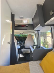 Intérieur aménagé d’un van avec lit et kitchenette