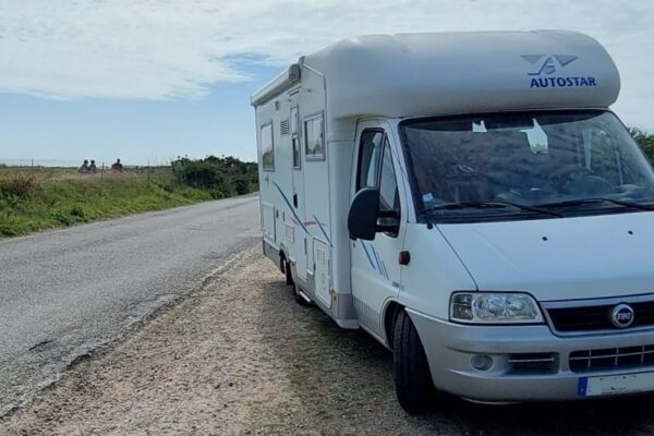Camping-car blanc stationné près de la côte