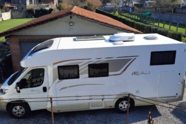 Wohnmobil weiß geparkt in einem Wohngebiet