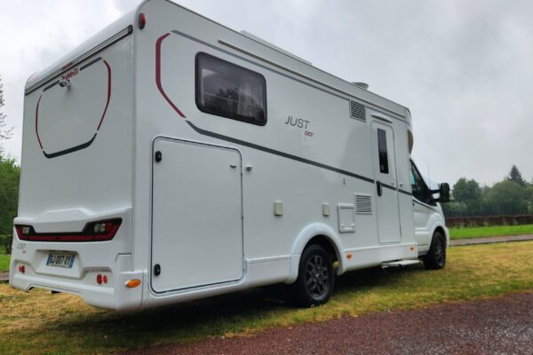 Camping-car blanc stationné sur pelouse verdoyante