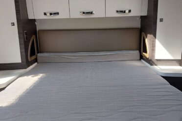 Zimmer von Wohnmobil mit Doppelbett und Stauraum