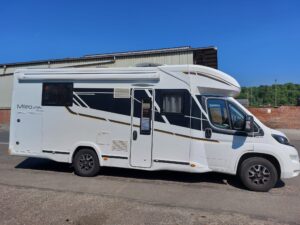 Camping-car blanc Mileo 296 garé en extérieur