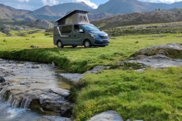 Van aménagé près d’un ruisseau en montagne