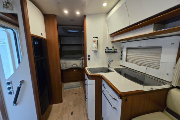 Cuisine moderne de camping-car avec lit au fond